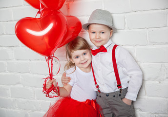 Little kids holding and picking up heart balloons. Valentine's Day and love concept, on white...