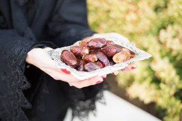 Middle Eastern Woman Offering Date Fruits for Ramadan