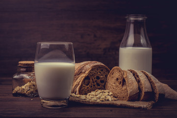 Glass of milk and pieces of brown bread.
