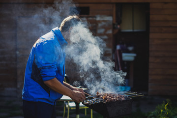 Man at a barbecue grill with smoke