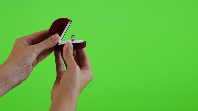 Silver ring in red box presenting in front of green screen 4K 2160p UltraHD footage - Green screen display presenting silver ring in female hands 4K 3840X2160 UHD video 