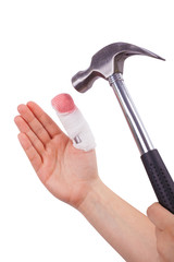 Isolated hand with injured finger is holding a hammer