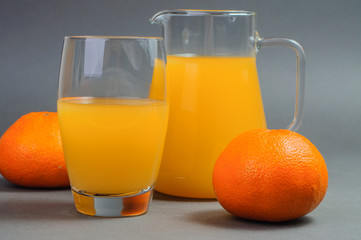 Obraz na płótnie Canvas Orange juice and two tangerines.