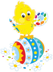 Little yellow chick painted an Easter egg
