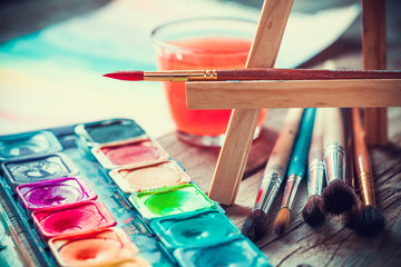 Fototapeta premium Set of watercolor paints and paintrushes for painting closeup. 