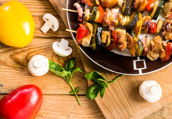 Grilled shish kebab with chicken, becon and vegetables.