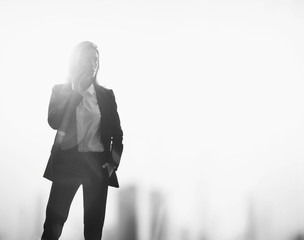 Black white photo of businesswoman, visual effects. Blurred city background. Horizontal