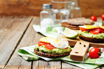 Fototapeta na wymiar smashed avocado, tomatoes, egg sandwich