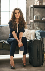 Woman with luggage in loft apartment waiting for departure