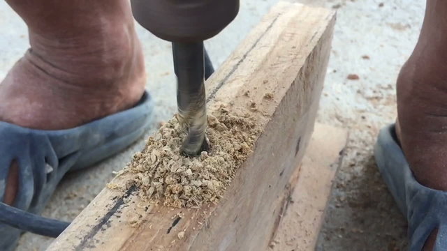 slow motion closeup drilling a screw into wood