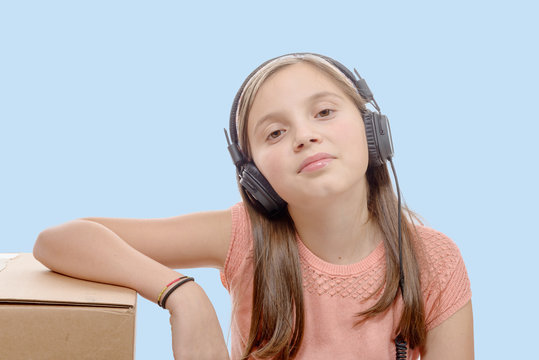  preteen listening to music with headphones, blue background