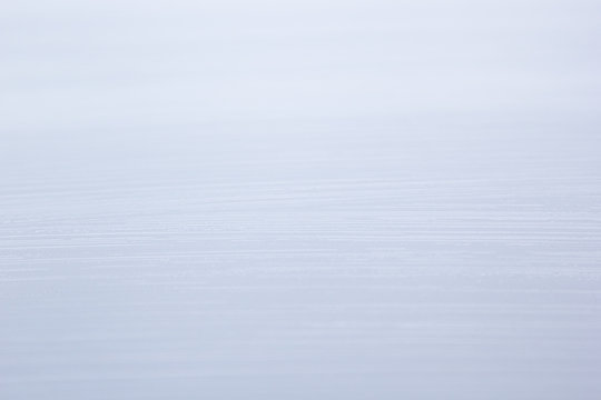The light striped texture water. The ight blue-gray surface. Background.