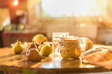 Fototapeta na wymiar homemade rustic jar of fruits with pears on wooden table - blur