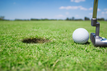 golf hole with putter and ball