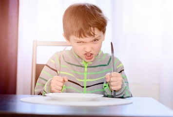Angry hungry boy child waiting for dinner