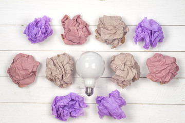 great idea concept with crumpled colorful paper and light bulb on wooden background