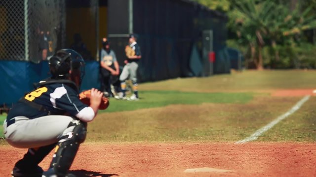 Slow motion of catcher receiving and throwing ball during baseball game