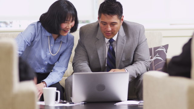 Business man and woman using laptop in office