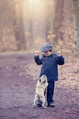 Fototapeta premium Cute little child, playing with little pet dog in the forest