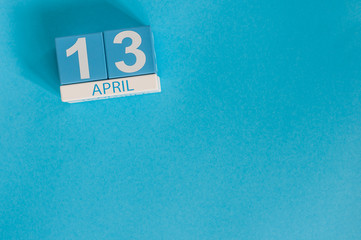 April 13th. Image of april 13 wooden color calendar on blue background.  Spring day, empty space...