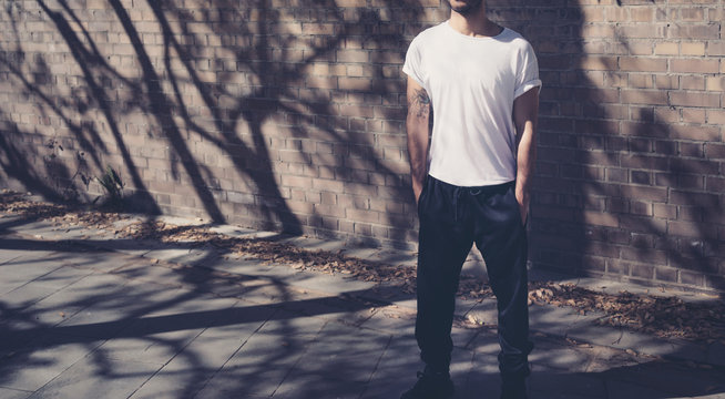 Photo Modern Man With Tattoo Wearing Blank White Tshirt. Stands In Front Of A Brick Wall. City Street Background. Horizontal Mockup. 