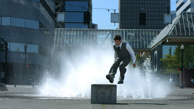 Business man does flip in front of city fountain
