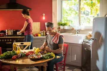 Wall murals Cooking Trendy couple cooking vegetables from the market in the kitchen