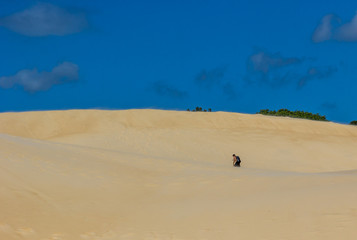 Homem caminhando nas dunas.
