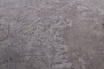 Cement Floor with texture and detailed on the surface plus cracking. The grey tone is from the coating on the floor.