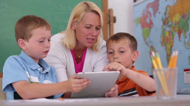 Teacher at school uses digital tablet in classroom