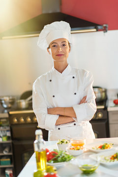 Portrait of a woman chef standing in the kitchen arms crossed.