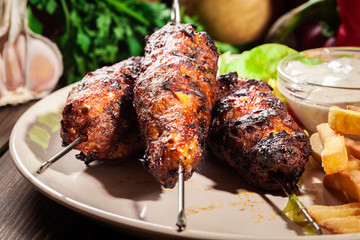 Grilled shish kebab served with fried chips and salad
