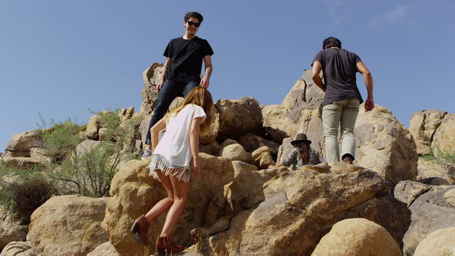 Friends climbing rocks