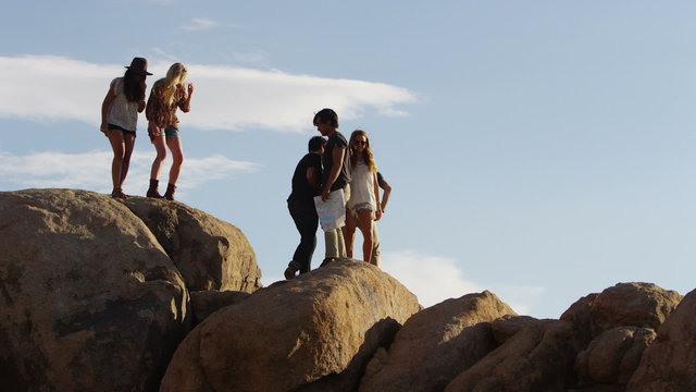 Friends climbing over rocks