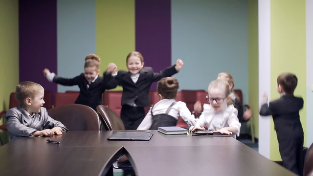 kids throw documents in air at business meeting