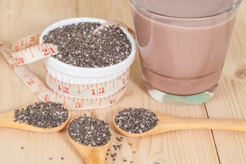 Nutritious chia seeds in bowl and spoon on a wooden