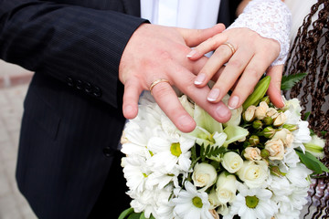 Obraz na płótnie Canvas Bride and groom hands with engagement rings and wedding bouquet