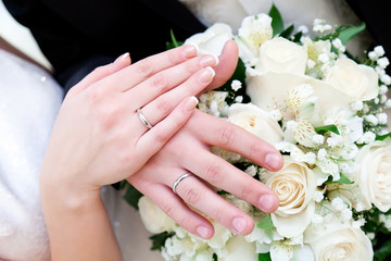 Obraz na płótnie Canvas Bride and groom hands with engagement rings and wedding bouquet