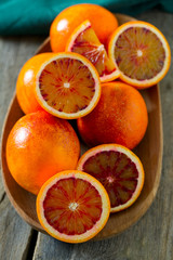 cut blood oranges on wooden surface