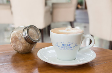 Cup of Art Latte coffee on the wooden desk