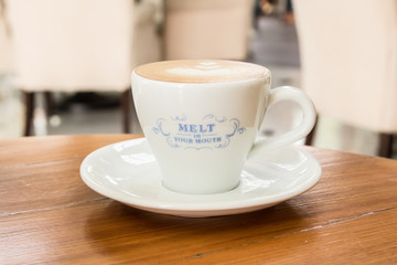 Cup of Art Latte coffee on the wooden desk