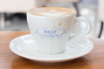 Cup of Art Latte coffee on the wooden desk