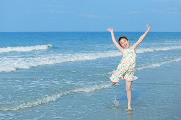 Fototapeta na wymiar Happy little girl on the beach