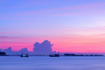 The sun sets behind a little jetty , sunset beach