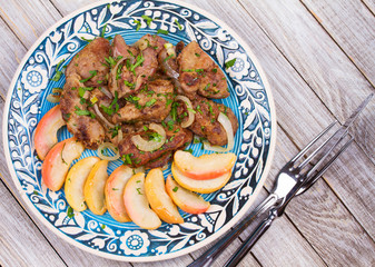 Sauteed chicken liver with apple and onion. View from above, top studio shot
