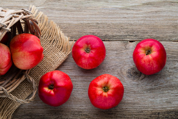 Ripe red apples on wooden background.