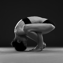 Yoga asana. Beautiful sexy body of young woman on black background