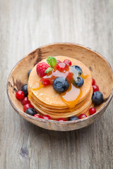 Stack of pancakes with blueberry and fresh berry.