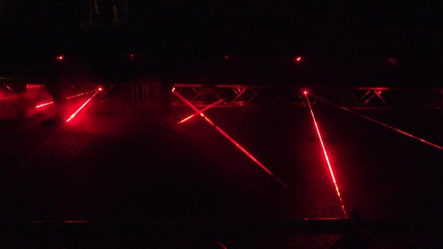red laser beams used in security demonstration at night. Static closeup shot.
