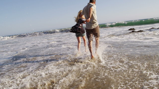 Couple splashing on the beach
